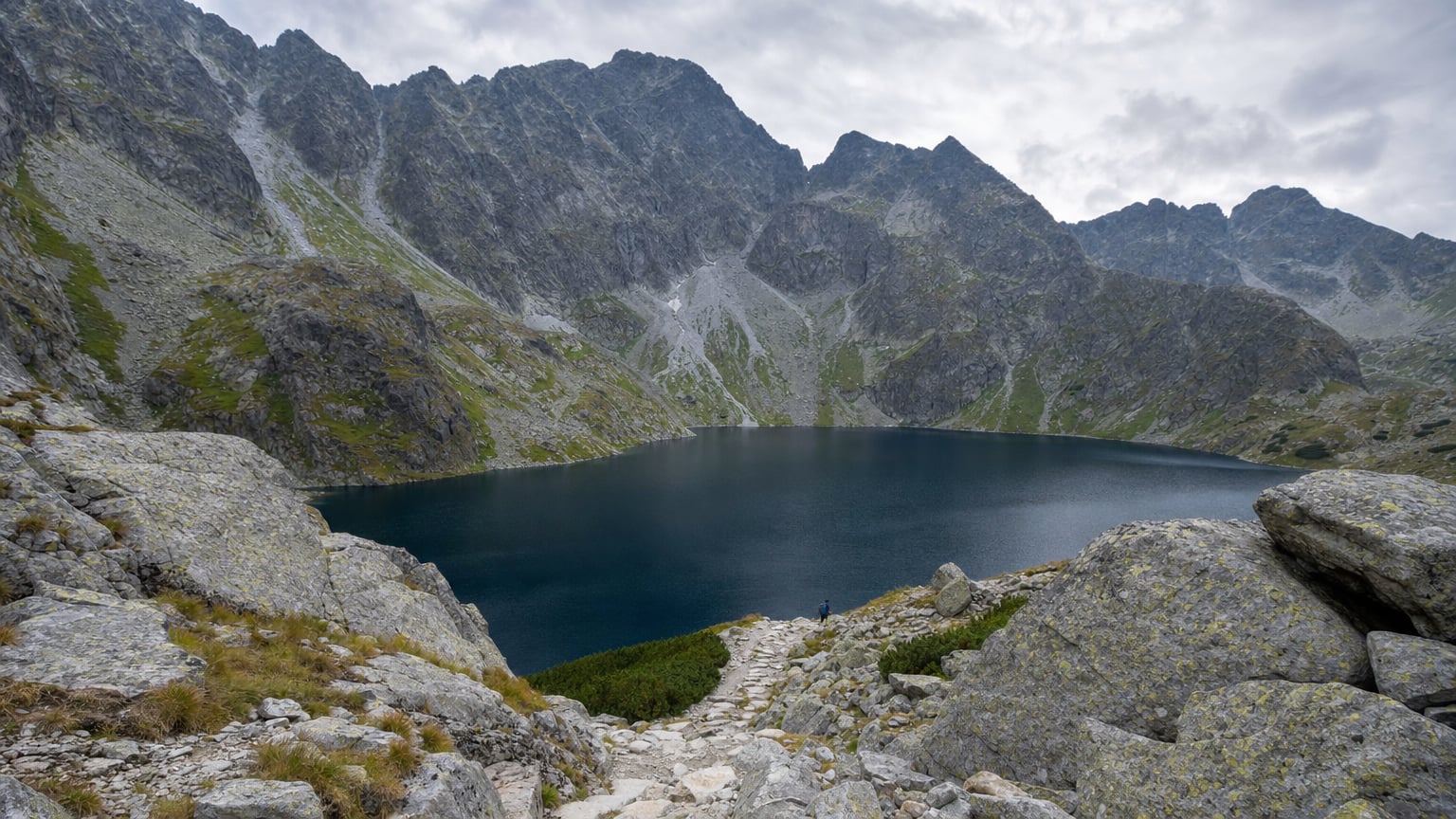 Czarny Staw pod Rysami to coś więcej niż krótki postój nad Morskim Okiem. Sprawdź, gdzie kończy się spacer, jak zmienia się charakter podejścia i dlaczego to miejsce bywa ważnym progiem przed Tatrami Wysokimi.